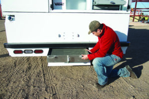 Man kneeling at the back of a truck